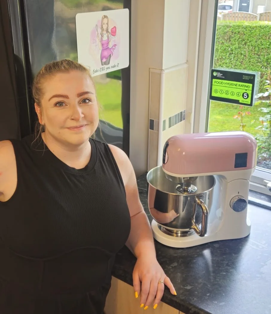 Amy standing beside a mixer in her kitchen